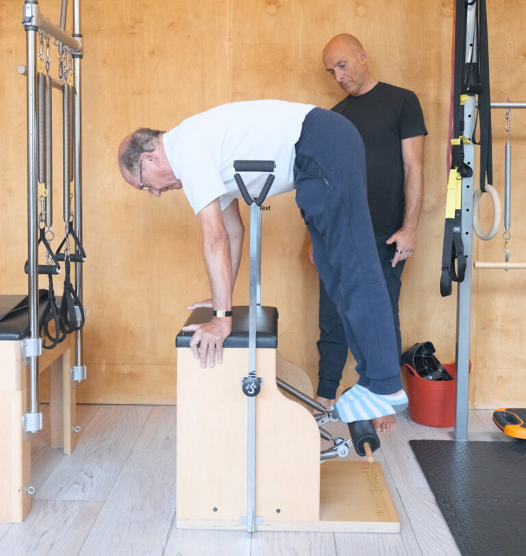 Man performing exercise on a pilates wundachair