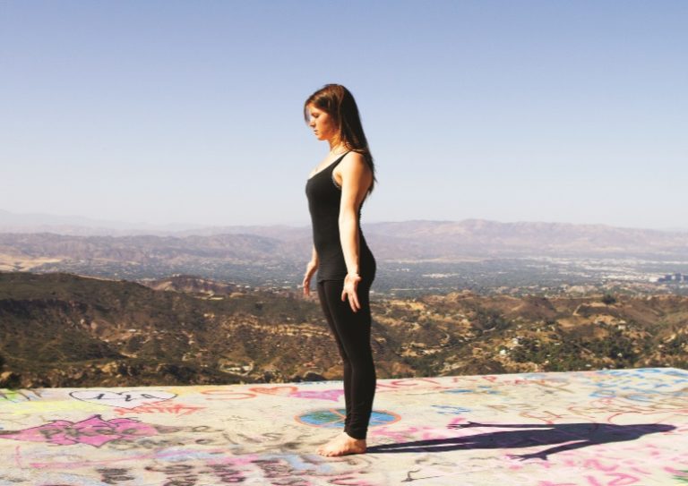 Lady doing yoga on hilltop. Alexandria Crow triyoga workshops.