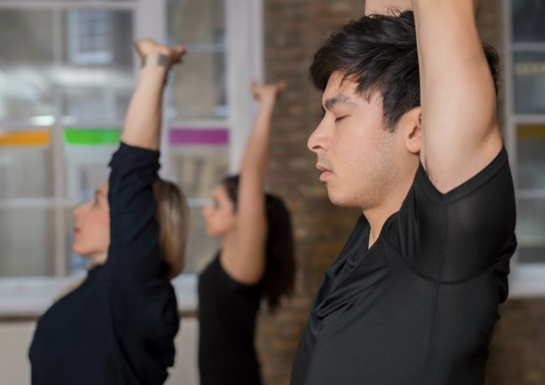young man with eyes closed doing yoga in studio triyoga, yoga for stress and the five vayus