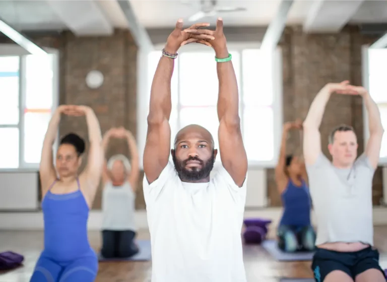 People practice different kinds of yoga at Triyoga in London. The room is bright and airy, with large windows that let in natural light