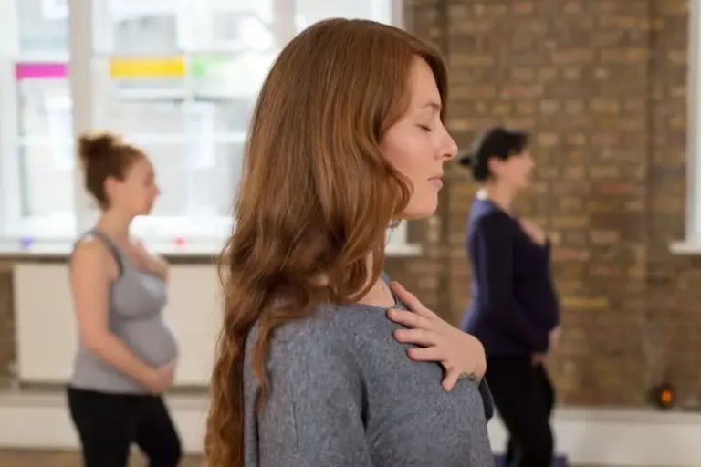 A group of pregnant women and new mothers are practicing yoga in a studio in London