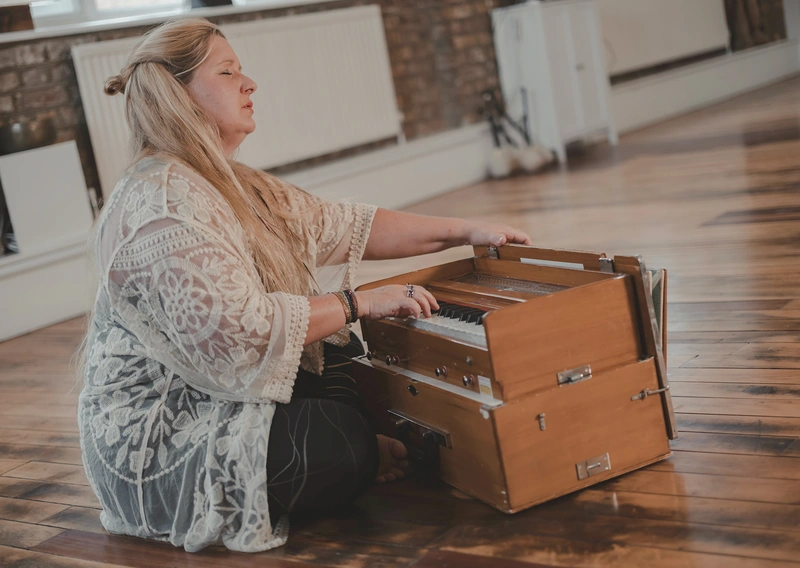 Woman playing harmonium on floor