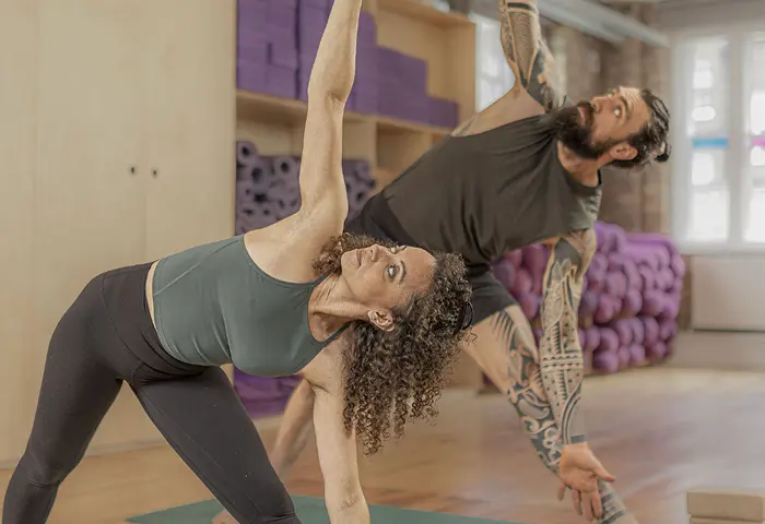 Two people practising yoga together.