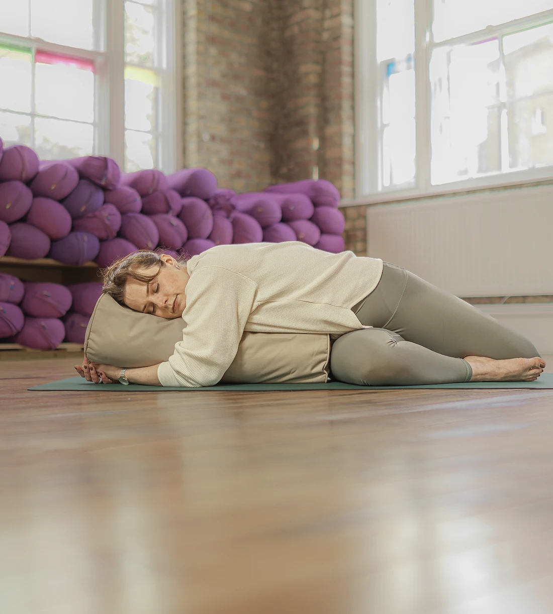 Person practising yoga with bolster